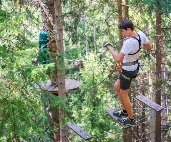 Teenager,Having,Fun,On,High,Ropes,Course,,Adventure,,Park,,Climbing